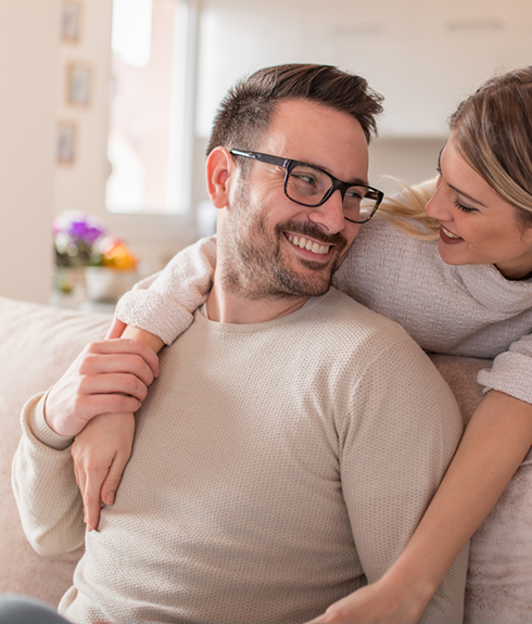 man with glasses, woman smiling because of no pain